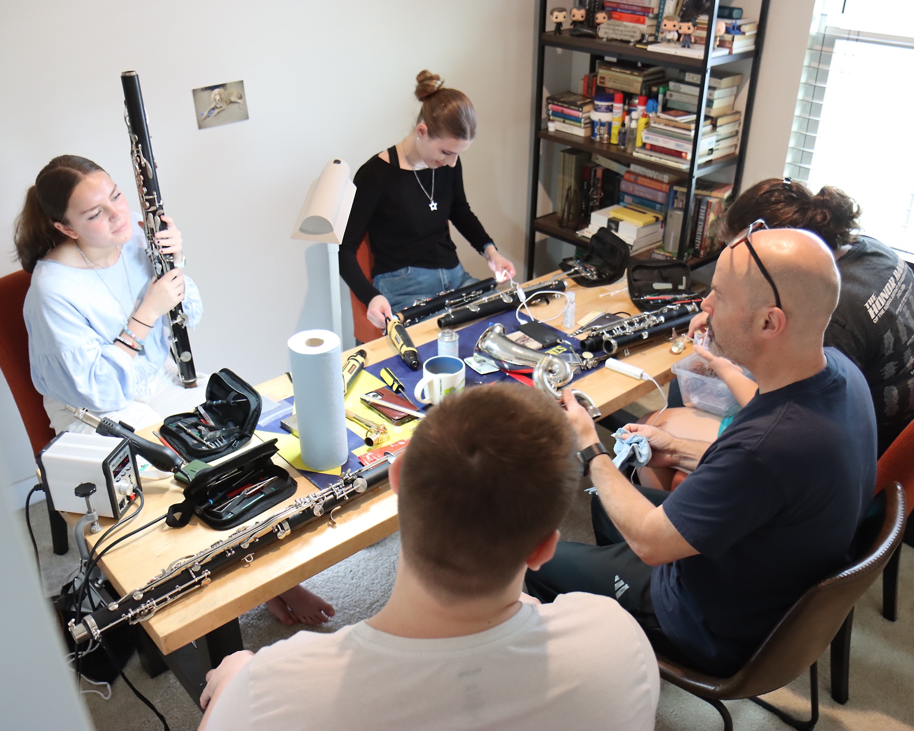 Scott Brady guiding students as they work with clarinets and repair tools around the Repair Camp bench