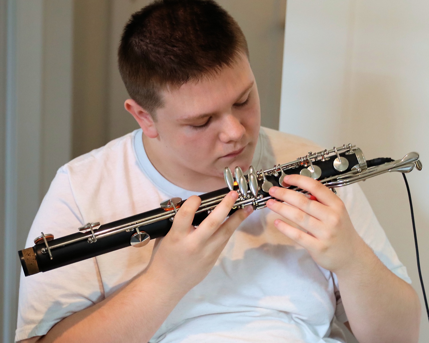 A Repair Camp student using an illuminated leak light to inspect a clarinet